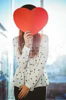 Attractive hipster woman behind a red heart