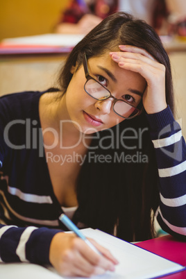 Thoughtful student studying on notebook