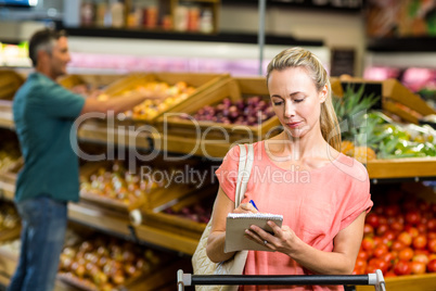 Pretty woman checking grocery list