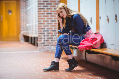 Worried student sitting in locker room and looking at the camera