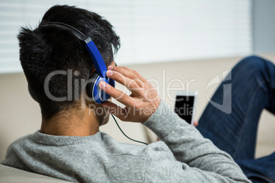 Over shoulder view of casual man listening music
