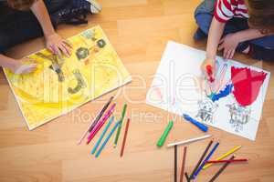 Two kids drawing together on sheets