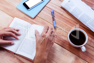 Overhead of feminine hands holding a book