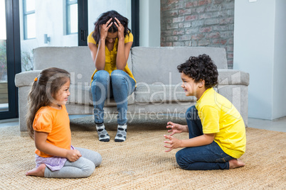 Fed up mother listening to her young children fight