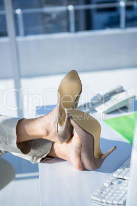 Businesswoman with her legs on her desk