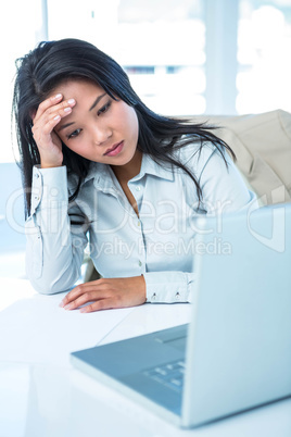 Worried businesswoman holding her head