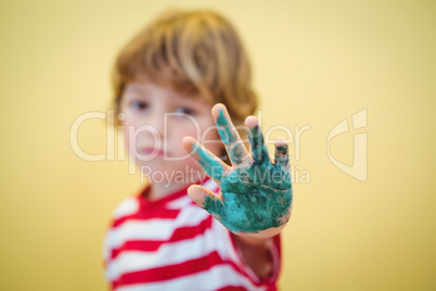 Boy holding up his paint covered hand