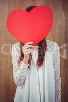 Smiling hipster woman behind a big red heart