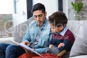 Happy father reading book with his son