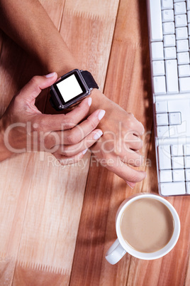 Feminine hands with smartwatch and coffee