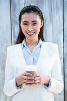 Portrait of smiling businesswoman with take-away coffee