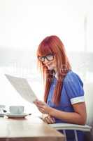 Smiling hipster woman looking at document