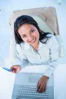 Smiling businesswoman holding credit card