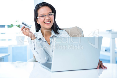 Smiling businesswoman holding credit card