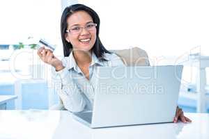 Smiling businesswoman holding credit card