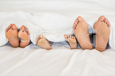 Familys feet out of a bed