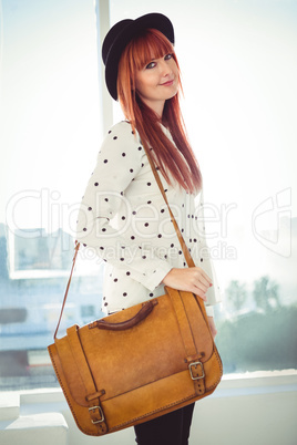 Portrait of a smiling hipster woman with a bag