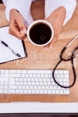 Doctor holding black coffee cup