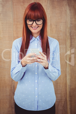 Smiling hipster woman texting on her smartphone