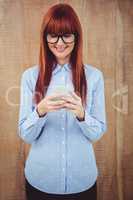 Smiling hipster woman texting on her smartphone