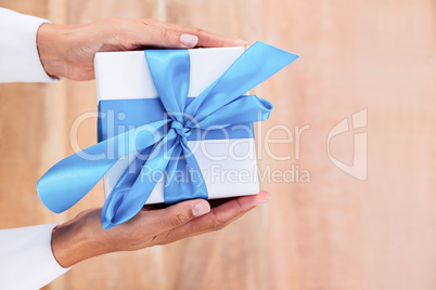Woman presenting gift with blue ribbon