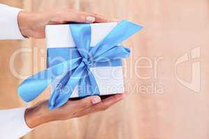 Woman presenting gift with blue ribbon