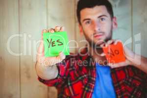 Handsome hipster showing yes and no cards