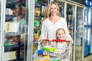 Smiling mother and daughter with cart