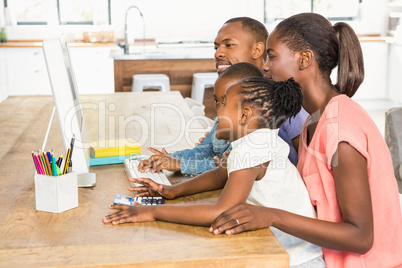 Smiling casual family on a computer