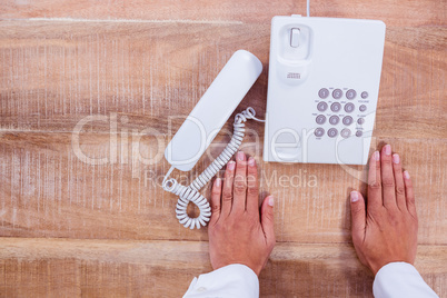Businesswoman holding a phone at her desk