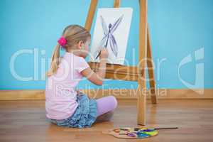 Girl sitting down painting a picture