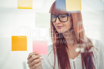 Attractive hipster woman looking at sticky notes