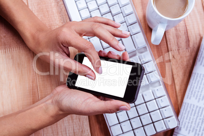 Businesswoman using her smartphone on desk