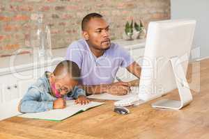 Cute son doing his homework with father