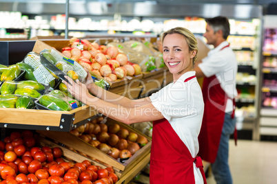 Smiling woman filling vegetables boxes