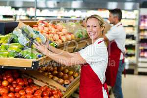 Smiling woman filling vegetables boxes