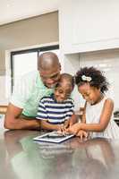 Father using tablet with his children in kitchen