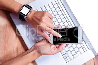 Woman with smartwatch using smartphone