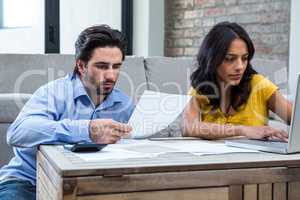 Couple in living room paying bills
