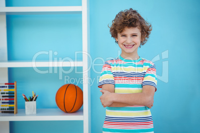 Smiling boy standing beside some toys