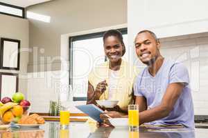 Young couple using tablet at breakfast