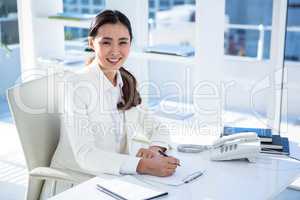 Smiling businesswoman taking down notes