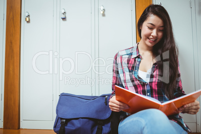 Smiling student sitting and reading a notebook Smiling student sitting and reading a notebook