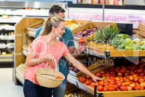 Happy couple holding tomatoes