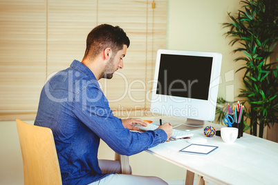 Handsome hipster working at desk