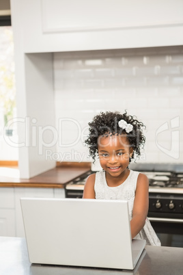 Girl with her laptop at the kitchen table