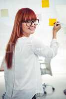 Attractive hipster woman writing on sticky notes