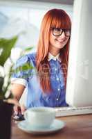 Attractive smiling hipster using computer