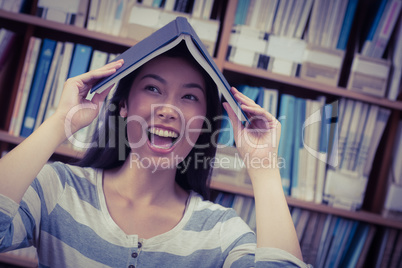 Funny student holding book on her head