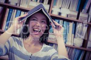 Funny student holding book on her head